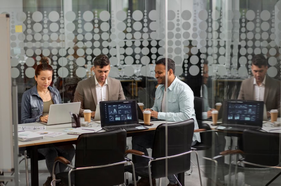 A group of people collaborating on laptops, discussing Managed IT Services For Small Businesses in Knoxville, TN, and cybersecurity.