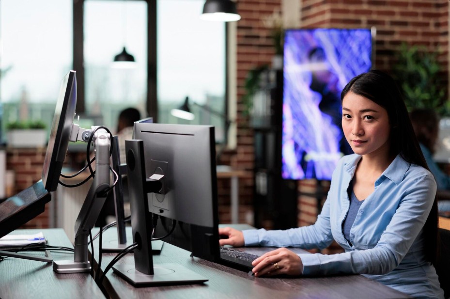 A woman at a desk with a computer, exploring managed IT services Knoxville for secured IT solutions and cybersecurity.