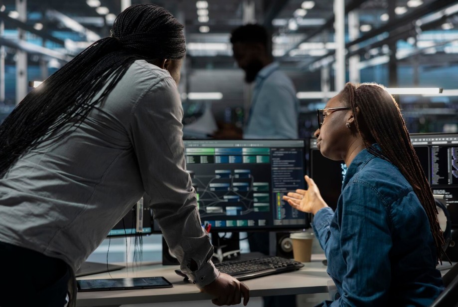 Two women collaborate on a computer, showcasing IT solutions at an IT Support Company in Greenville, SC, ensuring cybersecurity.